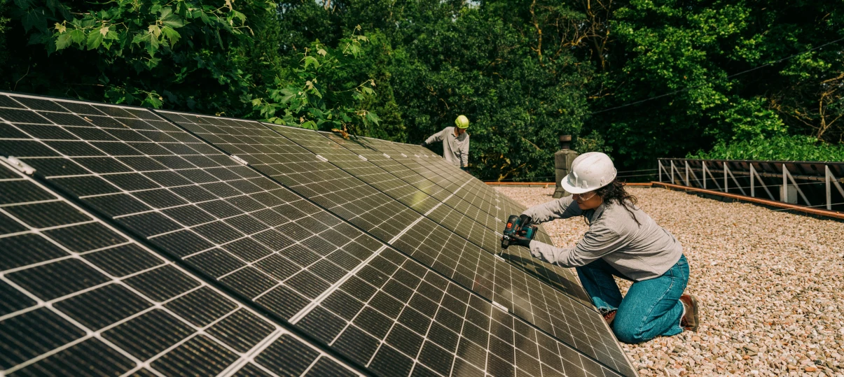 Dos operarios colocando una cubierta fotovoltaica para demostrar nuestra misión de favorecer el cambio energético hacia un futuro verde