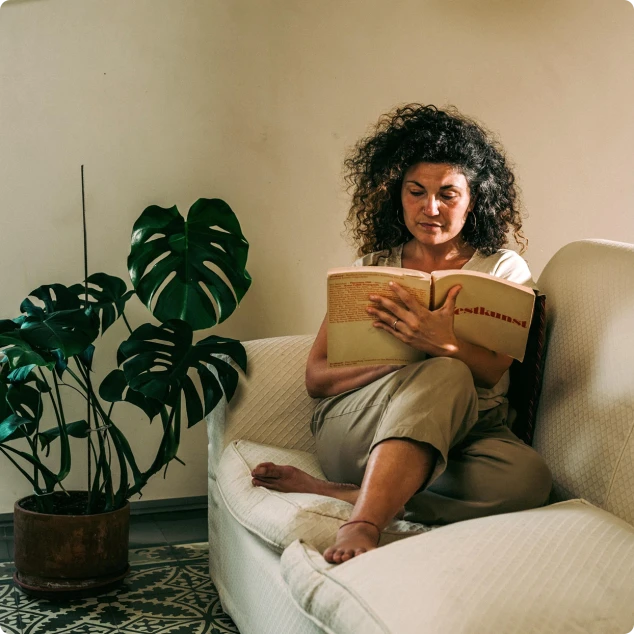 Mujer leyendo relajadamente sabiendo que va a recibir energía renovable a precio de coste por participar en el proyecto Generation kWh