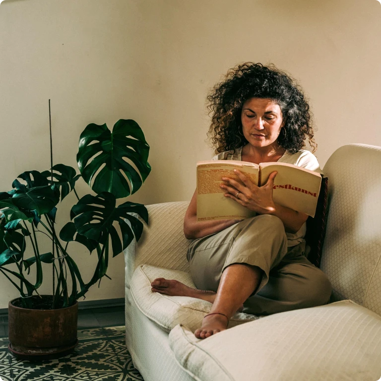 Mujer leyendo relajadamente sabiendo que va a recibir energía renovable a precio de coste por participar en el proyecto Generation kWh