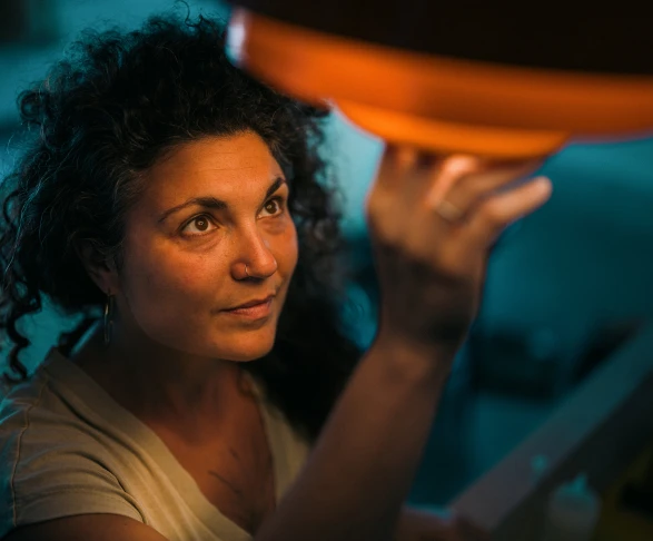 Mujer encendiendo la luz reflejando la energía limpia y justa que ofrece Som Energia, con un precio transparente que refleja el coste real y sin intereses ocultos