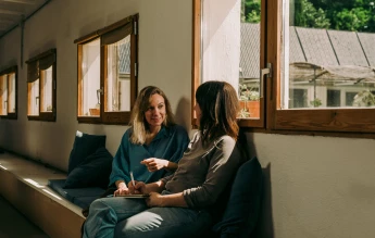 Dos mujeres hablando sobre el poder de las palabras y la comunicación inclusiva de la cooperativa