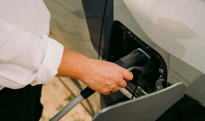 Persona cargando coche eléctrico